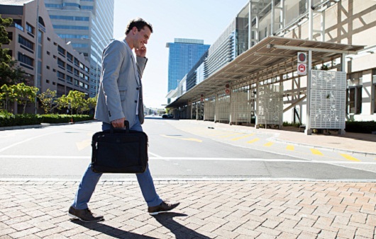 Man on phone walking across street