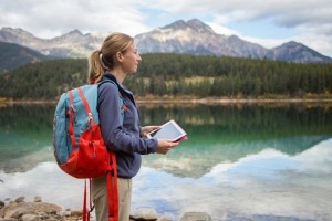 Young woman hiking by the lake using digital map