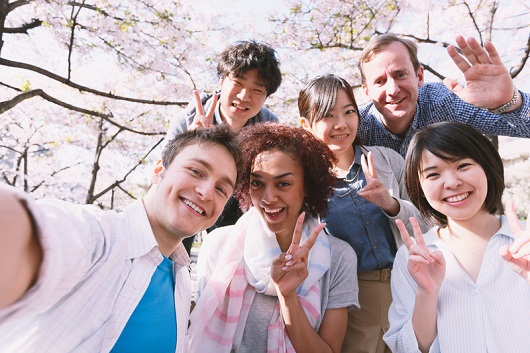 Multi-ethnic group of friends enjoying cherry blossoms blooming in Tokyo