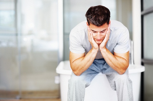 Man with hand in hands sitting at bathtub