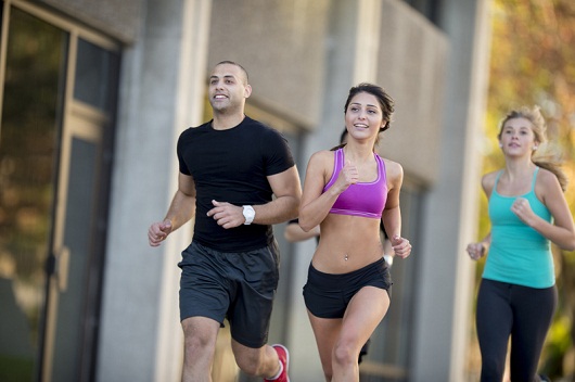 A multi-ethnic group of friends are running outside during their workout.