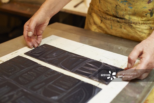 Printmaker preparing press to make lino print